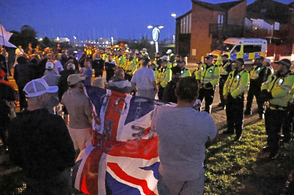 Protesters gather as migrant dinghy heads for south coast