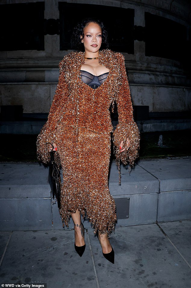 Rihanna commands attention in a garish blood orange co-ord as she arrives at Matières Fécales show during Paris Fashion Week