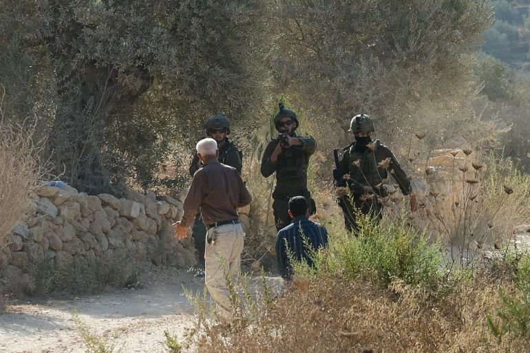 Israeli settlers attack West Bank olive pickers, soldiers assault reporters