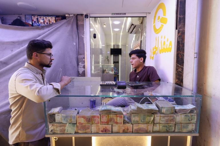 Why has Iraq devalued its currency, and why are some MPs against it?
