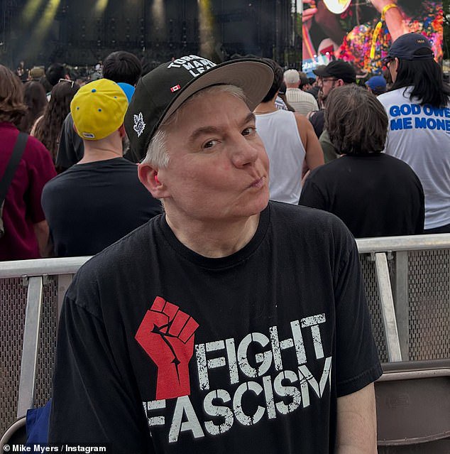 Mike Myers, 63, looks younger than ever as he wears an edgy ‘Fight Fascism’ T-shirt at politically-charged rock concert