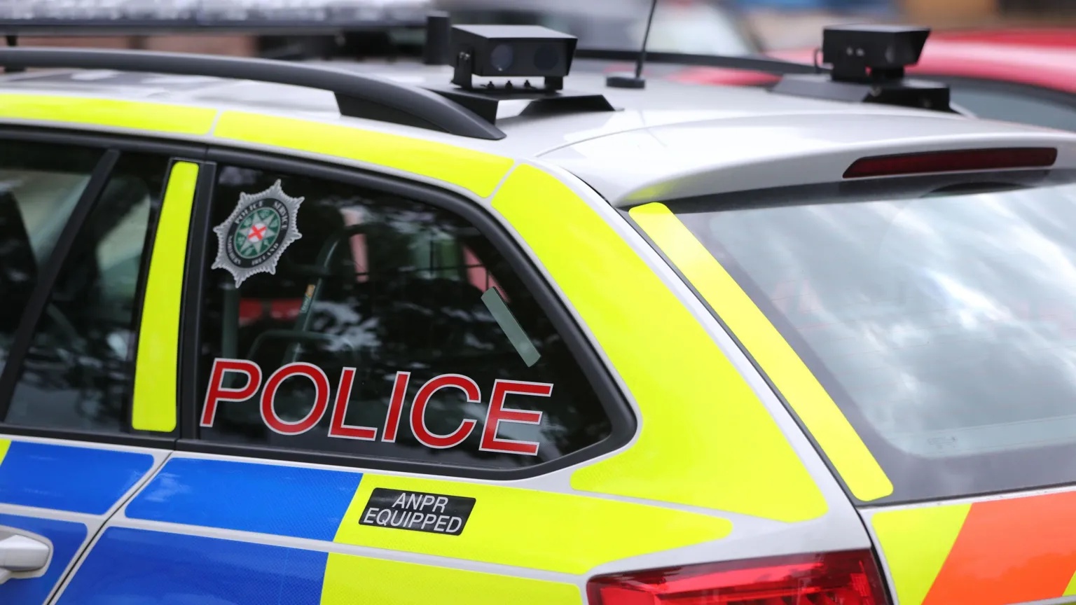 Masked men throw petrol bombs at police car