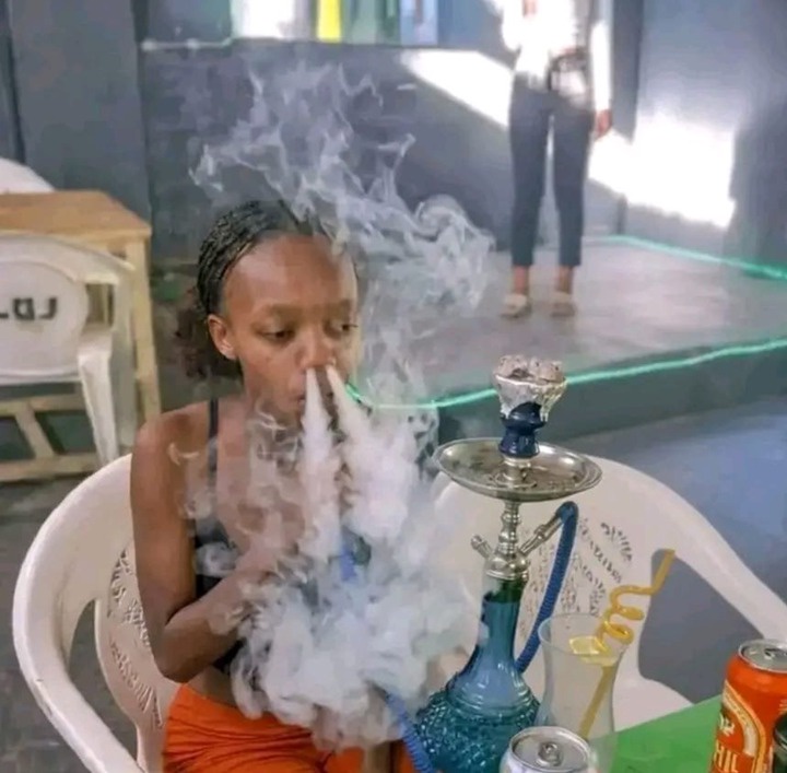 Young woman filmed smoking a hookah at a club and blowing smoke through her nose
