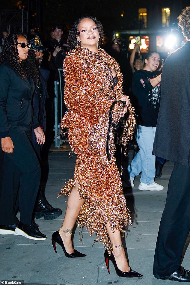 Rihanna commands attention in a garish blood orange co-ord as she arrives at Matières Fécales show during Paris Fashion Week