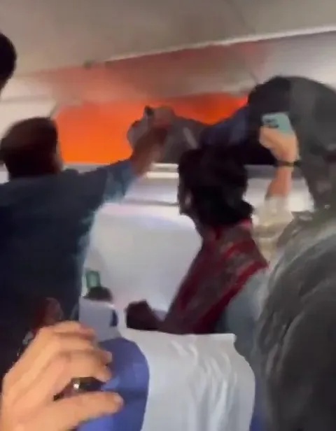 Terrifying moment power bank bursts into flames on packed flight as passengers desperately try to put out blaze