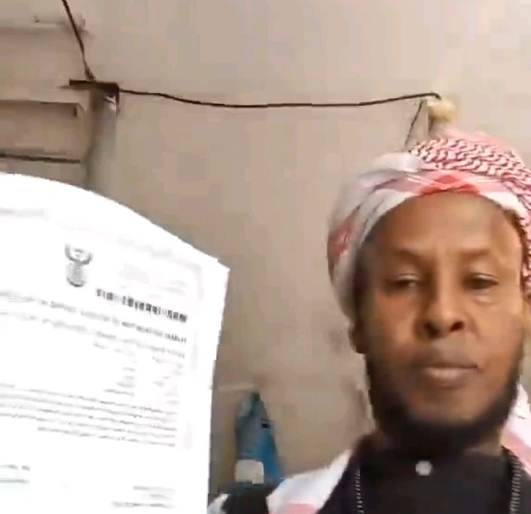 Man shows off asylum documents and says his paperwork is staying in South Africa