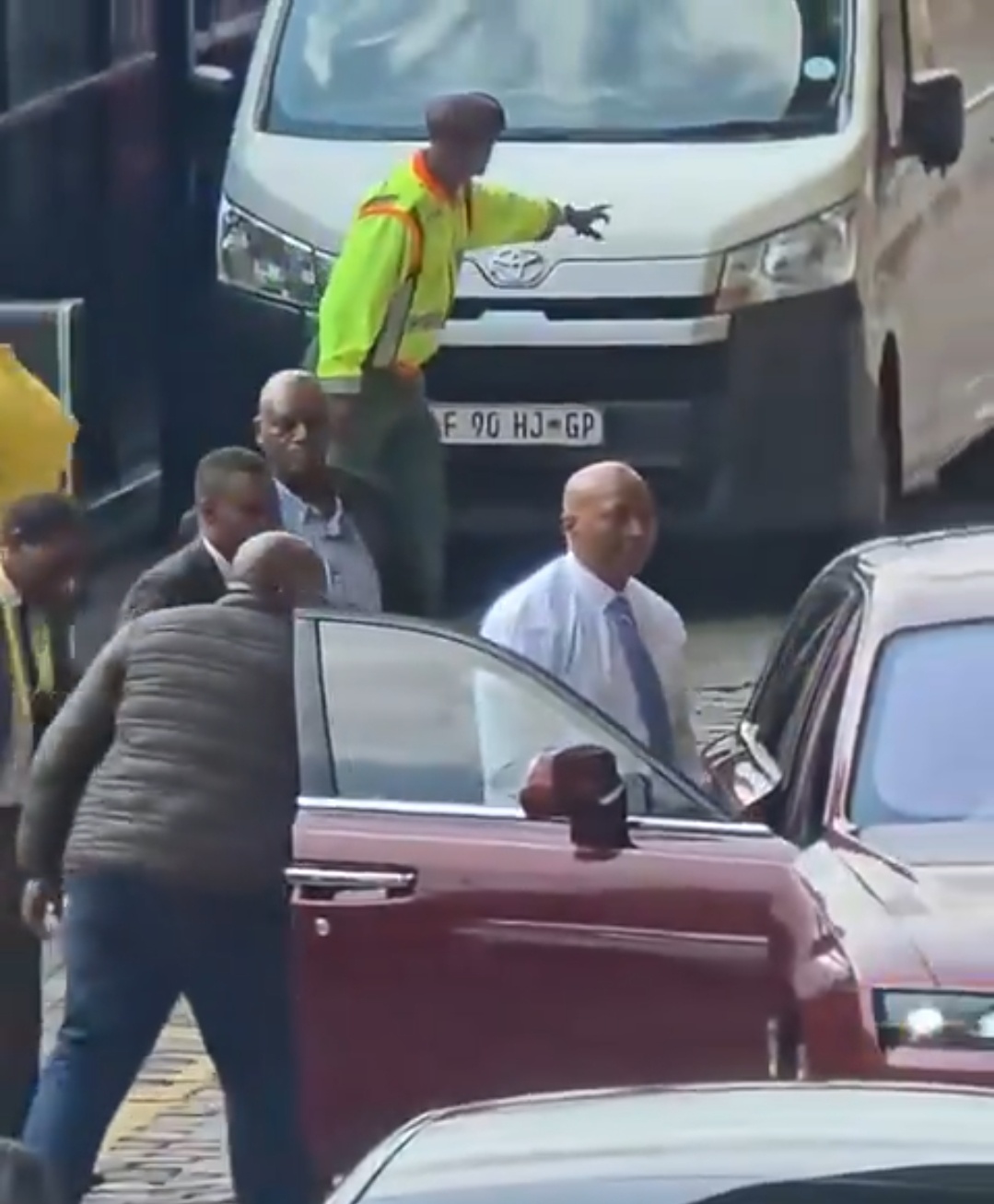 Billionaire Patrice Motsepe drives his own red Rolls Royce through a busy street