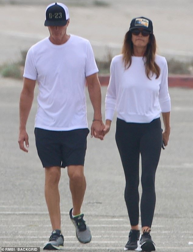 Cindy Crawford and Rande Gerber hold hands on beach in somber outing three weeks after son Presley died aged 27 at rehab facility